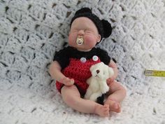 a baby doll with a pacifier in it's mouth