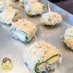 several appetizers with toothpicks in them on a metal tray