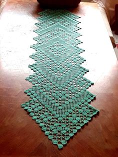 a green table runner sitting on top of a wooden table