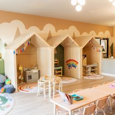 a child's play room with wooden houses and toys on the floor in front of them