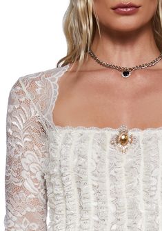 This long sleeve top has a sheer floral lace construction, a front vertical ruffled design, a scalloped lace neckline, and a front removable gemstone brooch with a pin closure. Elegant Long Sleeve Lace Top With Ruffles, Elegant Long Sleeve Lace Top With Scalloped Edges, Elegant Long Sleeve Scalloped Lace Top, Formal Long Sleeve Tops With Scalloped Lace, Long Sleeve Lace Top With Scalloped Lace For Evening, Elegant Ruffled Lace Top, Feminine Long Sleeve Lace Top For Evening, Gemstone Brooch, Sugar Thrillz