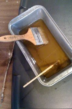 a wooden spoon is sitting on top of a plastic container filled with brown liquid