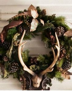 a wreath with deer antlers and pine cones