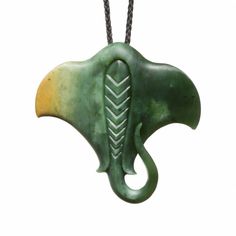 a green and yellow pendant with an elephant's head