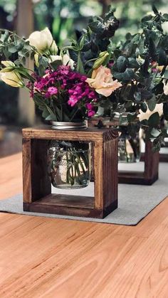 three vases with flowers in them sitting on a table