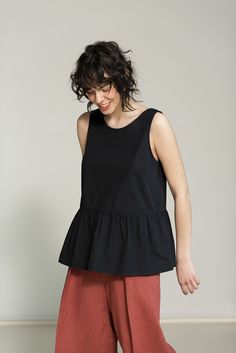 This airy top is handmade from pure cotton-poplin, has a pleated peplum waist and a beautifully folded plunge back. The loose A-shape and elegant neckline make for a versatile and effortless design and feel. Like all our pieces, this cotton top is carefully crafted - it has French seams and bias tape finishing. The top is easily combined with crop tops, sweaters and blouses. Item: Handmade and made to order Material: 100% cotton poplin, OEKO-TEX® certified Fit: Relaxed Style: Casual/Formal Sleeves: Sleeveless Pockets: No Back: Open Colors:       - White       - Black       - Navy Blue       - Pink       - Light Blue If you'd love to have this top in a different color or size, we'd be happy to custom-make one for you.  Feel free to contact us at any time with questions and suggestions! We a Cotton Peplum Tops, Sleeveless Summer Peplum Top, Chic Sleeveless Cotton Peplum Top, Summer Cotton Peplum Top, Summer Cotton Peplum Blouse, Summer Peplum Cotton Blouse, Cruise Capsule Wardrobe, Cotton Peplum Top, Spring Tank Tops