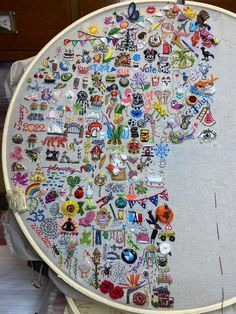 a large embroidery piece with many different designs on it's side and the shape of a tree