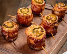 some food is sitting on top of a wooden board with toothpicks in it