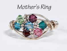 This personalized Mother's Ring with 7 birthstones, showcases your loved one's birthstones with an elegant look. We make this Mother's ring using 7 Swarovski birthstone crystals, sterling silver beads, and layers of sterling silver wire that we wrap around a mandrel at your custom size. Our 7 crystal Mother's rings are a great gift for both mothers and grandmothers. If you have a need for a different number of crystals that is more or less than shown above in the photos please check out the link Suede Choker Necklace, Birthstone Crystals, Mother's Ring, Birthstone Ring Mothers, Grandmother Jewelry, Family Ring, Family Rings, Mom Ring, Mother Jewelry