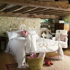 a white bed sitting inside of a bedroom on top of a hard wood floor