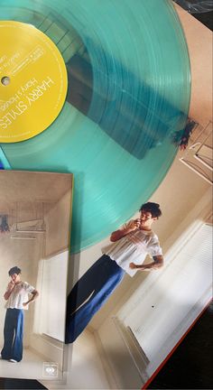 two blue records are sitting on top of a table next to an album and a yellow disc