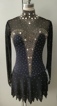 a mannequin wearing a black dress with pearls on it