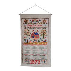 a cross stitch banner hanging on a wall with the year 1932 written in red and blue