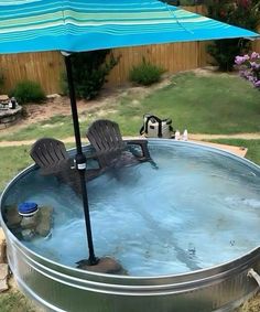 an umbrella and chairs are in the middle of a large metal tub filled with water