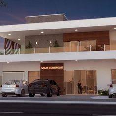 two cars are parked in front of a building with balconies on the second floor