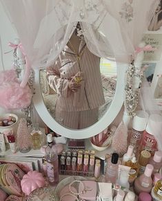 there is a vanity with pink accessories on it and a mirror in the corner above it