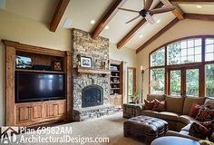 a large living room with stone fireplace and vaulted ceiling