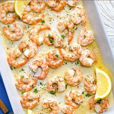 a pan filled with shrimp and lemon on top of a table