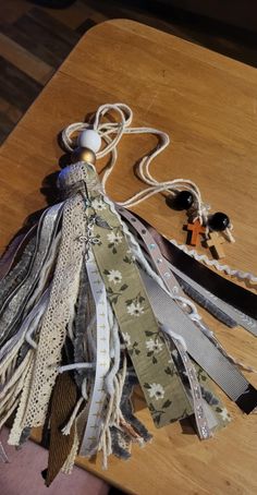 a wooden table topped with different types of ribbons and beads on top of each other