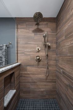 an instagram photo of a bathroom with tile and wood accents on the shower wall