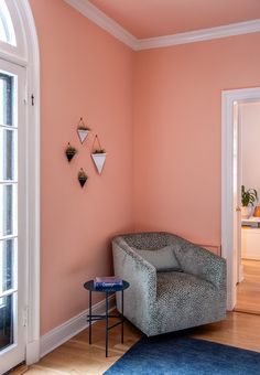 a living room with pink walls and blue rug