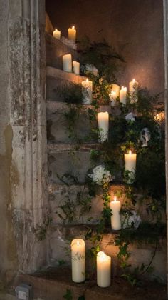 candles are lit in front of an open window with ivy growing on the outside wall