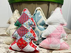 three pillows sitting on top of a wooden table next to a potted planter