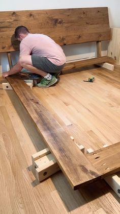 a man working on a wooden bed frame