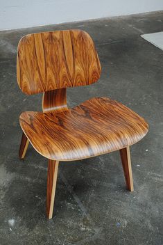 a wooden chair sitting on top of a cement floor