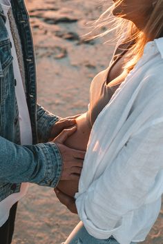 two people standing next to each other holding hands