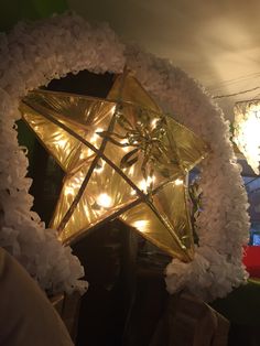 a gold star surrounded by white flowers and lights