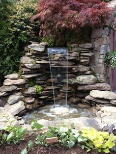 a small waterfall in the middle of a garden