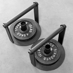 two black and white photo of dumbbells on the ground with their handles extended