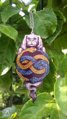 a monkey with a snake on it's back hanging from a tree