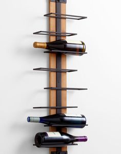 a wall mounted wine rack with three bottles on it's sides and two corks in the middle