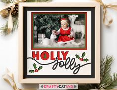 a christmas card with an image of a baby in a red dress and holly decorations