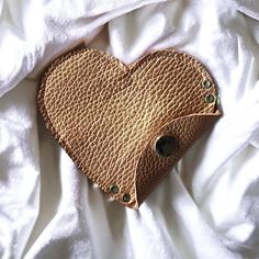 a heart shaped purse sitting on top of a white sheet