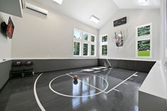 an indoor basketball court is shown in the middle of a room with high ceilings and large windows