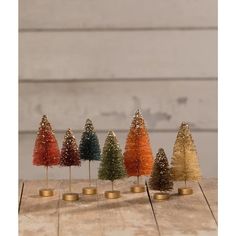 small christmas trees are lined up on the table