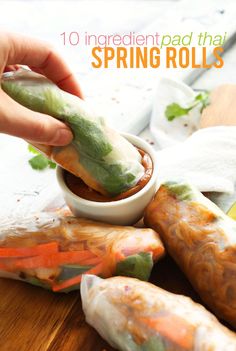 an image of spring rolls being dipped with dipping sauce and garnished with cilantro