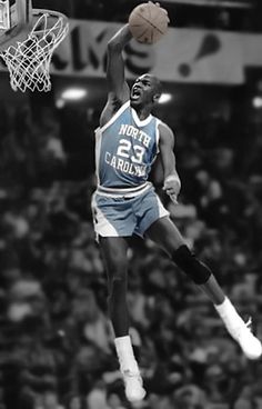 an old black and white photo of a basketball player jumping up to dunk the ball