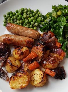 a white plate topped with potatoes, carrots and green beans next to peas on a table