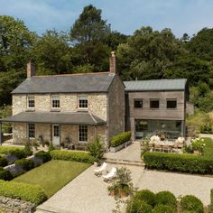 an aerial view of a stone house surrounded by greenery