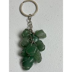 a bunch of green beads hanging from a metal keychain