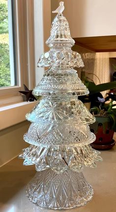 a glass christmas tree sitting on top of a table