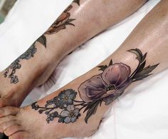 two people with flower tattoos on their legs