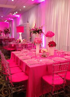 the tables are set with pink linens and flowers