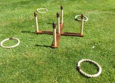 two wooden poles and ropes in the grass with one ring on it's side