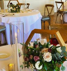 an arrangement of flowers and greenery is displayed in the center of this dining room