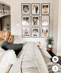 a living room filled with lots of pictures on the wall and furniture in front of it